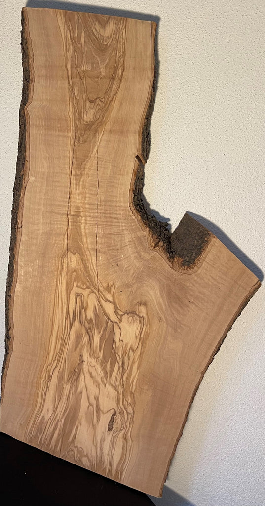 Naturbelassene Olivenholzbohle mit einzigartiger Maserung, Astloch und lebendiger Farbzeichnung, ideal für kreative Holzprojekte oder Möbelbau.