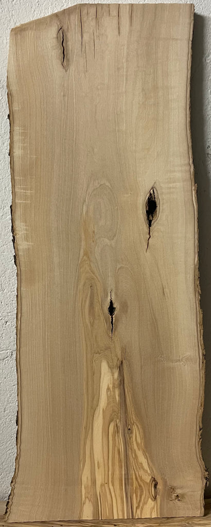 Rustikales Olivenholzbrett mit naturbelassener Rinde an den Seiten, fein gehobelt und mit markanten Maserungen, Astlöchern und kleinen Rissen – ideal für handgefertigte Schneidebretter oder Unikate aus Holz.