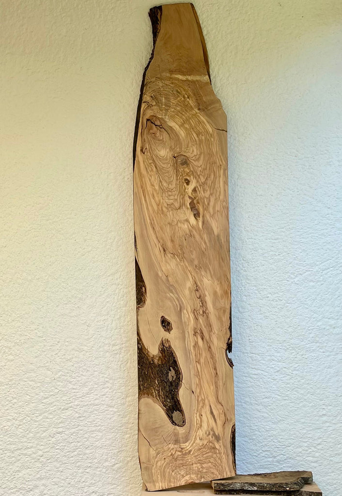 Langes Olivenholzbrett mit markanter Maserung und Naturkante, 183 cm Länge, 36 cm Breite.