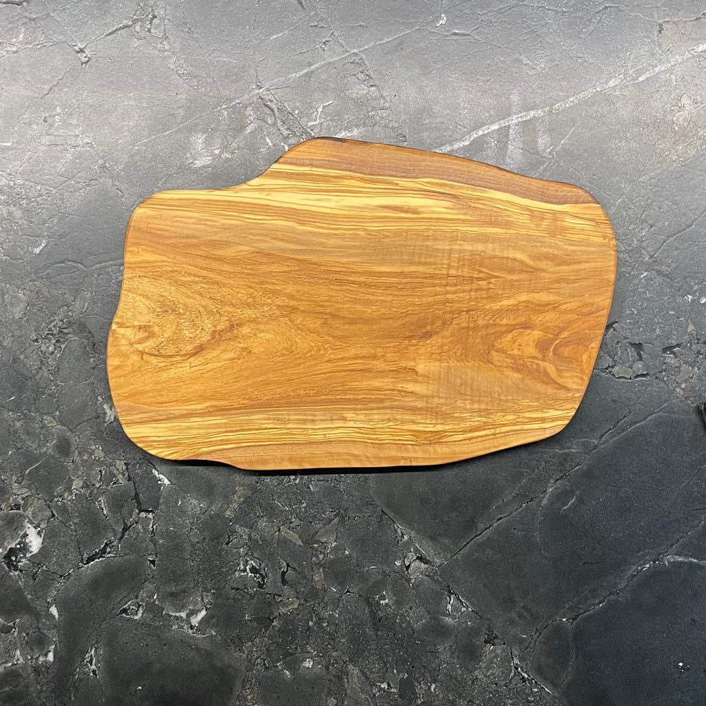 Rückseite eines massiven Olivenholzbretts mit naturbelassener, warmer Holzfarbe.