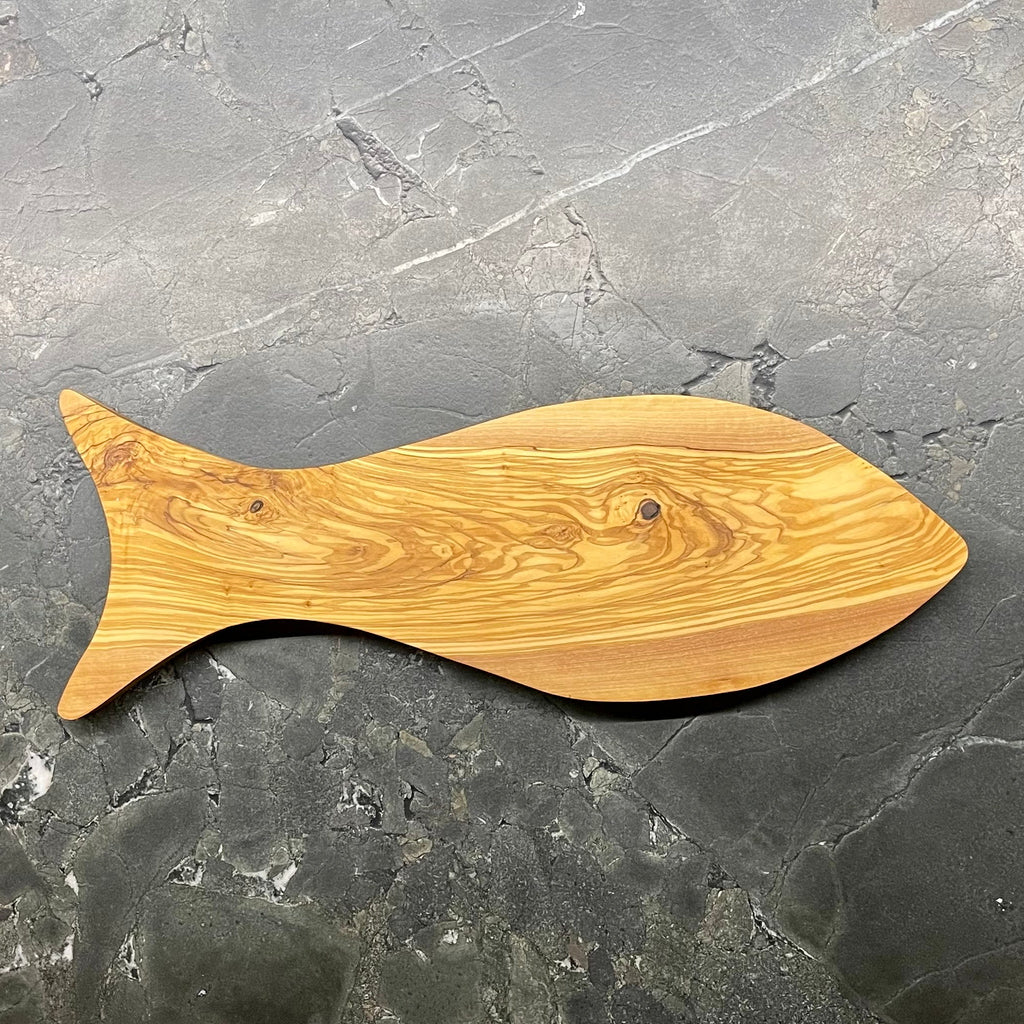 Handgefertigtes Schneidebrett aus Olivenholz in Fischform S474 auf Steinoberfläche