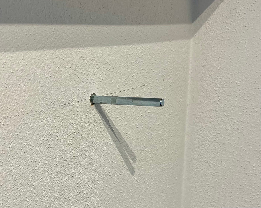 Tablarhalter für Olivenholz-Regalbrett in eine weisse Wand montiert