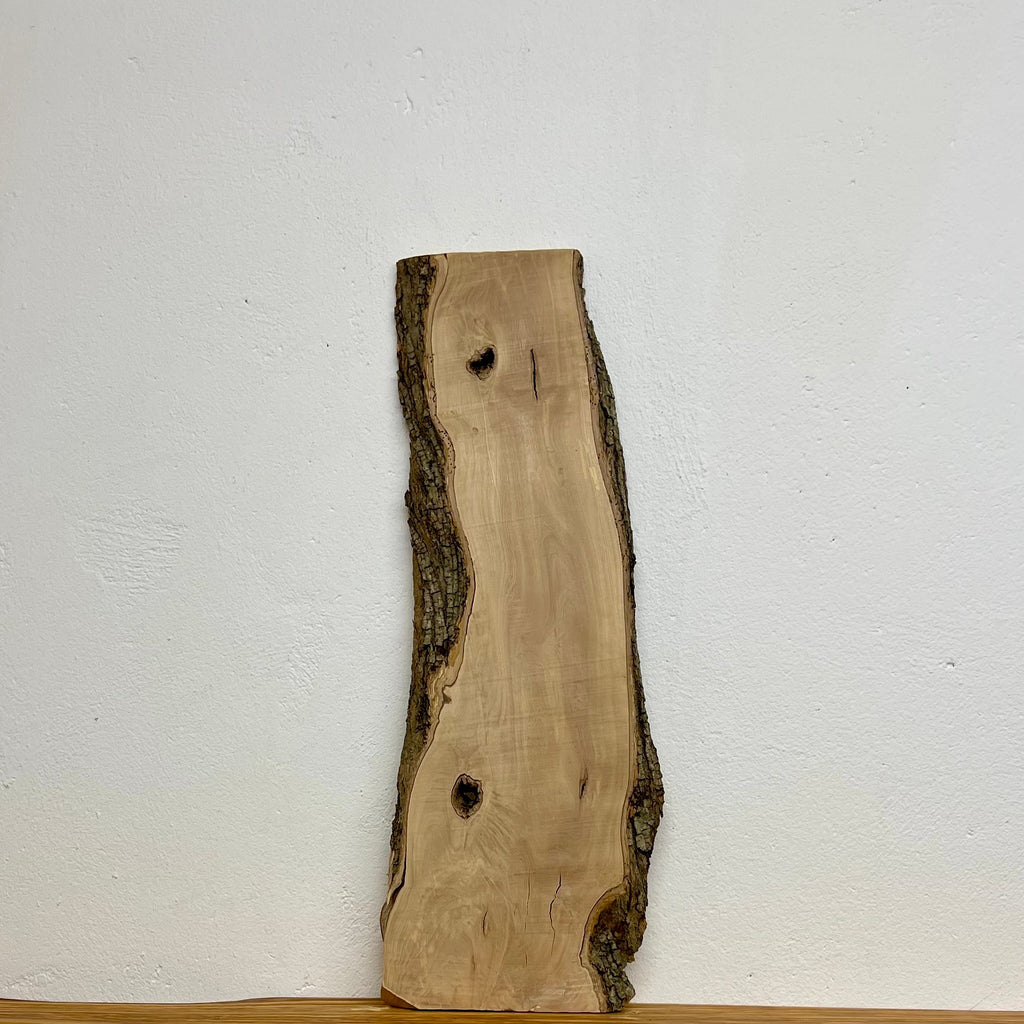Olivenholz-Brett W505 mit beidseitiger Naturkante und Rinde, 670 × 230–170 × 20 mm.