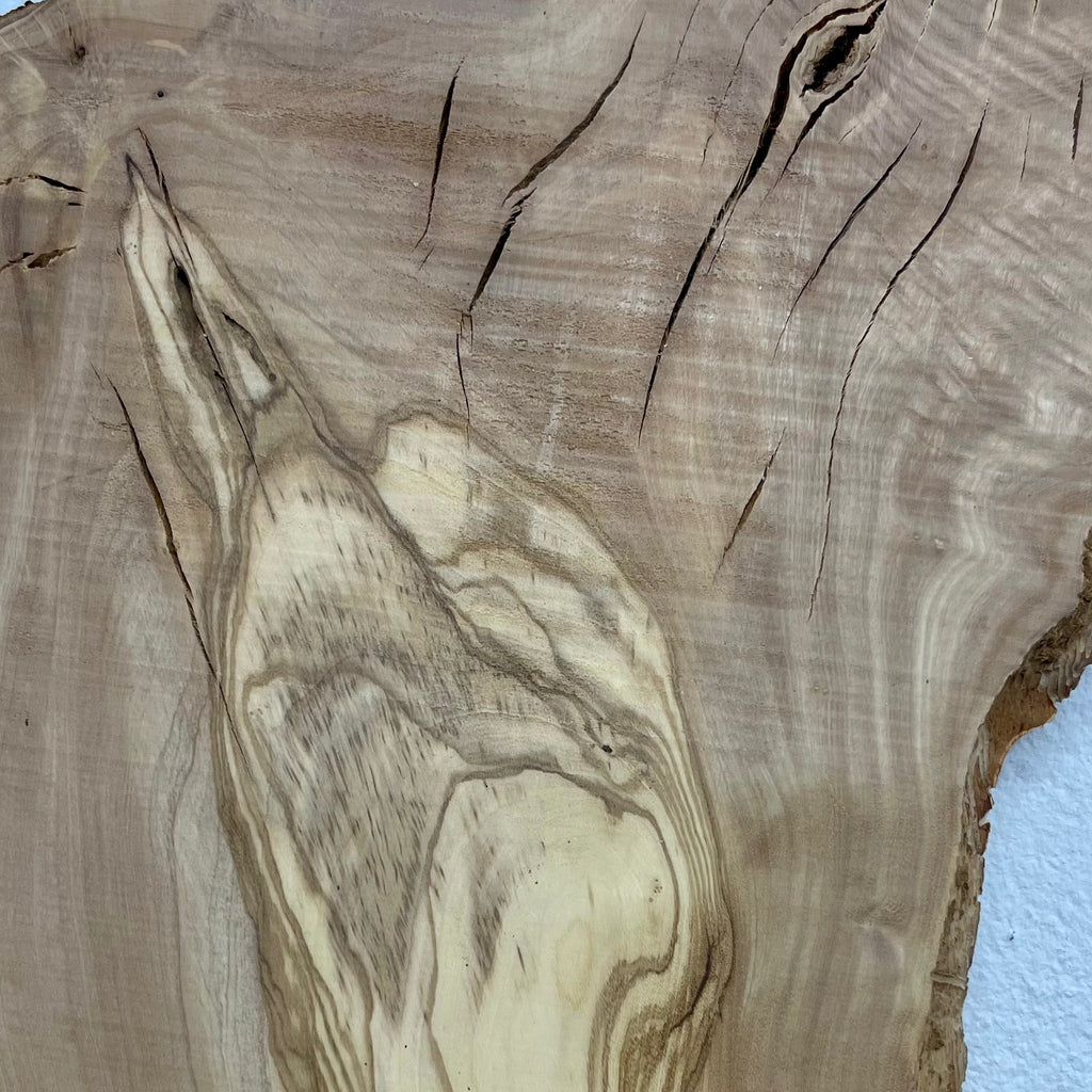 Detail des Olivenholz-Bretts W506 mit Rissen und mediterraner Maserung.