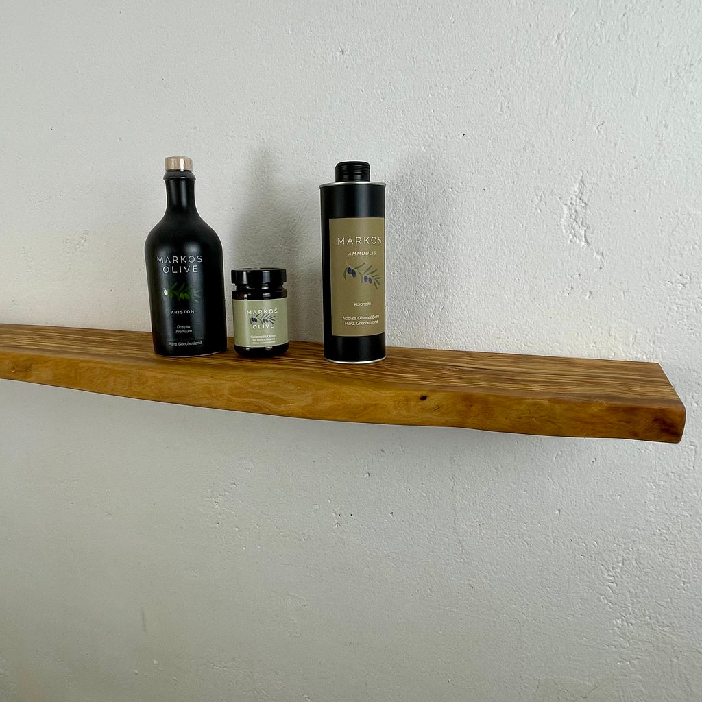 Wandboard aus Olivenholz mit Naturkante, dekoriert mit Olivenölprodukten