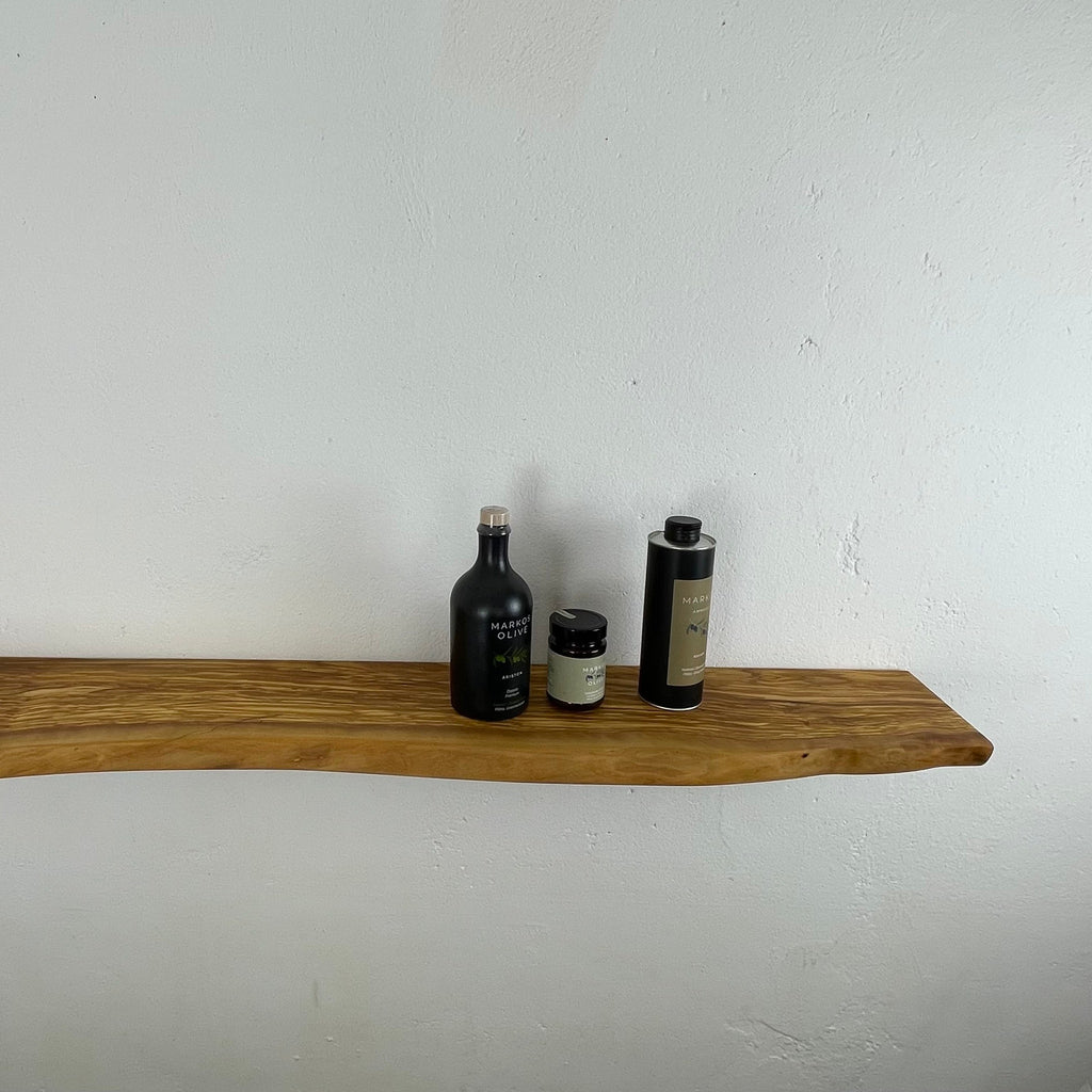 Olivenholzregal an weißer Wand, ruhige Maserung mit organischer Form