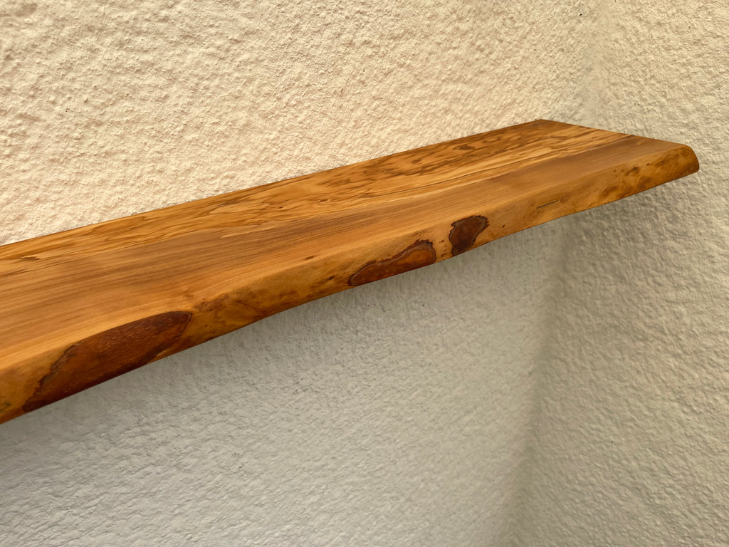 An Wand montiertes Regalbrett aus Olivenholz mit natürlicher Form