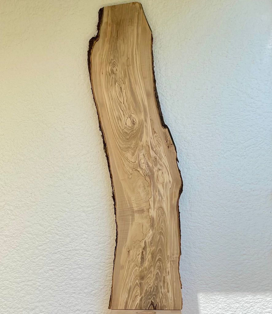 Längsansicht eines 154 cm langen Olivenholzbretts mit markanter Naturkante und charaktervoller Maserung